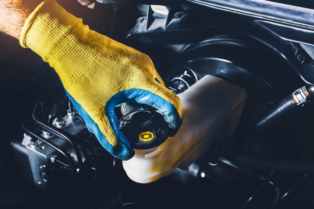 technician performing a vehicle fluid exchange